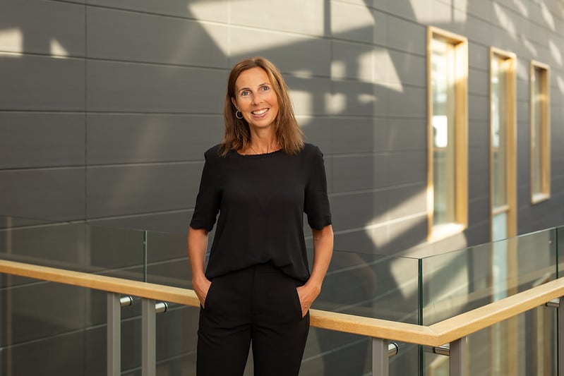 Bilde av ei smilande Marianne Skjeldestad Hove. Ho er kledd i svart genser og bukse.